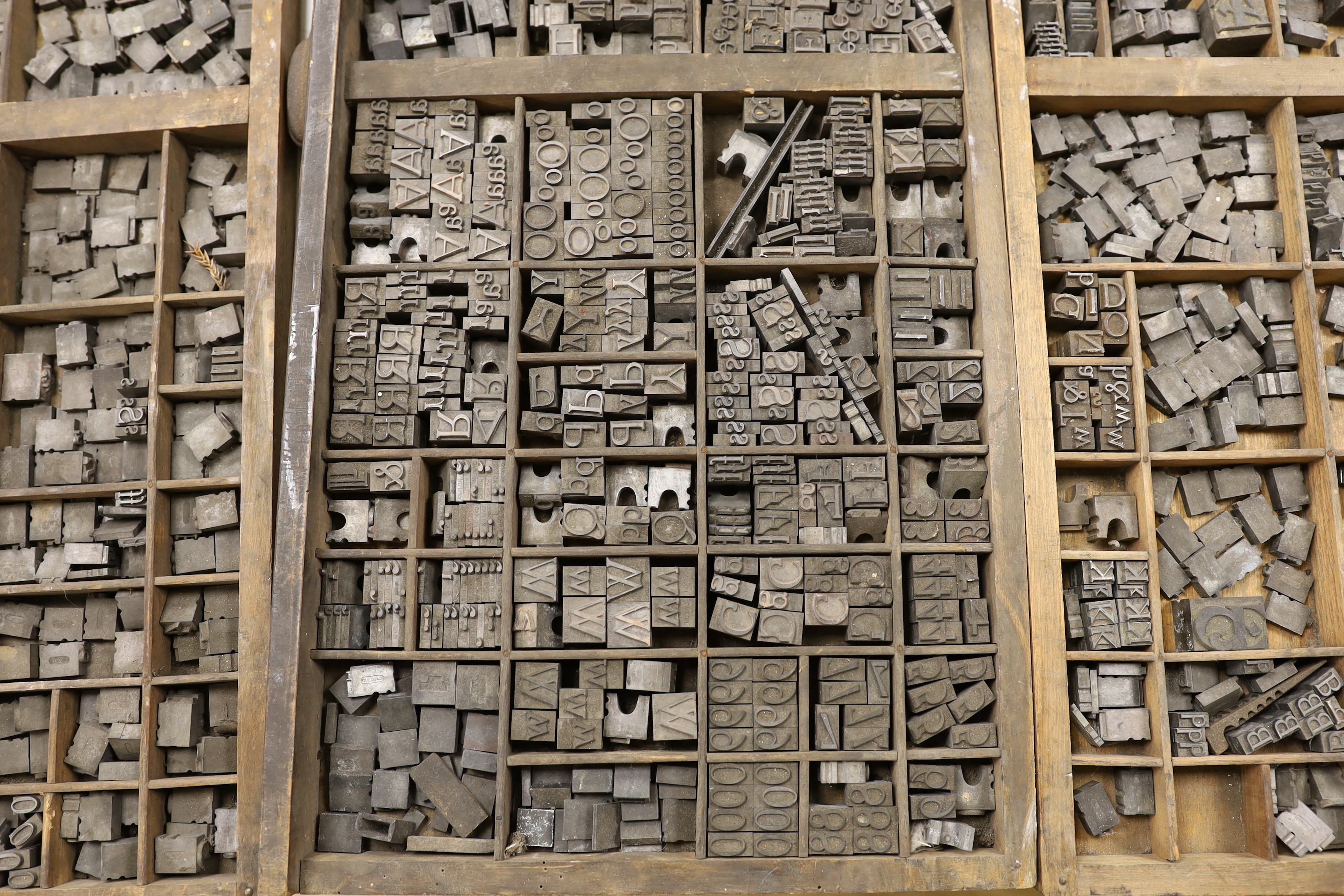 Three trays of metal printing type: chases, quoins and spacing bars